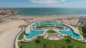 A resort with a large central pool, a beach area, and a view of the ocean. - One 1402C Studio: Relaxing Oceanview Studio at Sonoran Star (Puerto Peñasco)