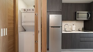 A modern kitchen with a built-in microwave, a refrigerator, and a washing machine. - One 1402C Studio: Relaxing Oceanview Studio at Sonoran Star (Puerto Peñasco)