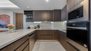Eine moderne Küche mit eingebauten Geräten, Holzschränken und einer Marmarbeplatte.
