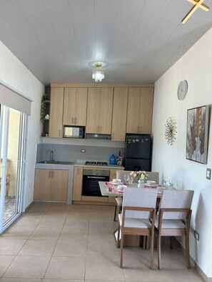 A modern kitchen with wooden cabinets, a built-in microwave, and a gas stove. - Bella Vista House with a View of the San Salvador Volcano (San juan opico)