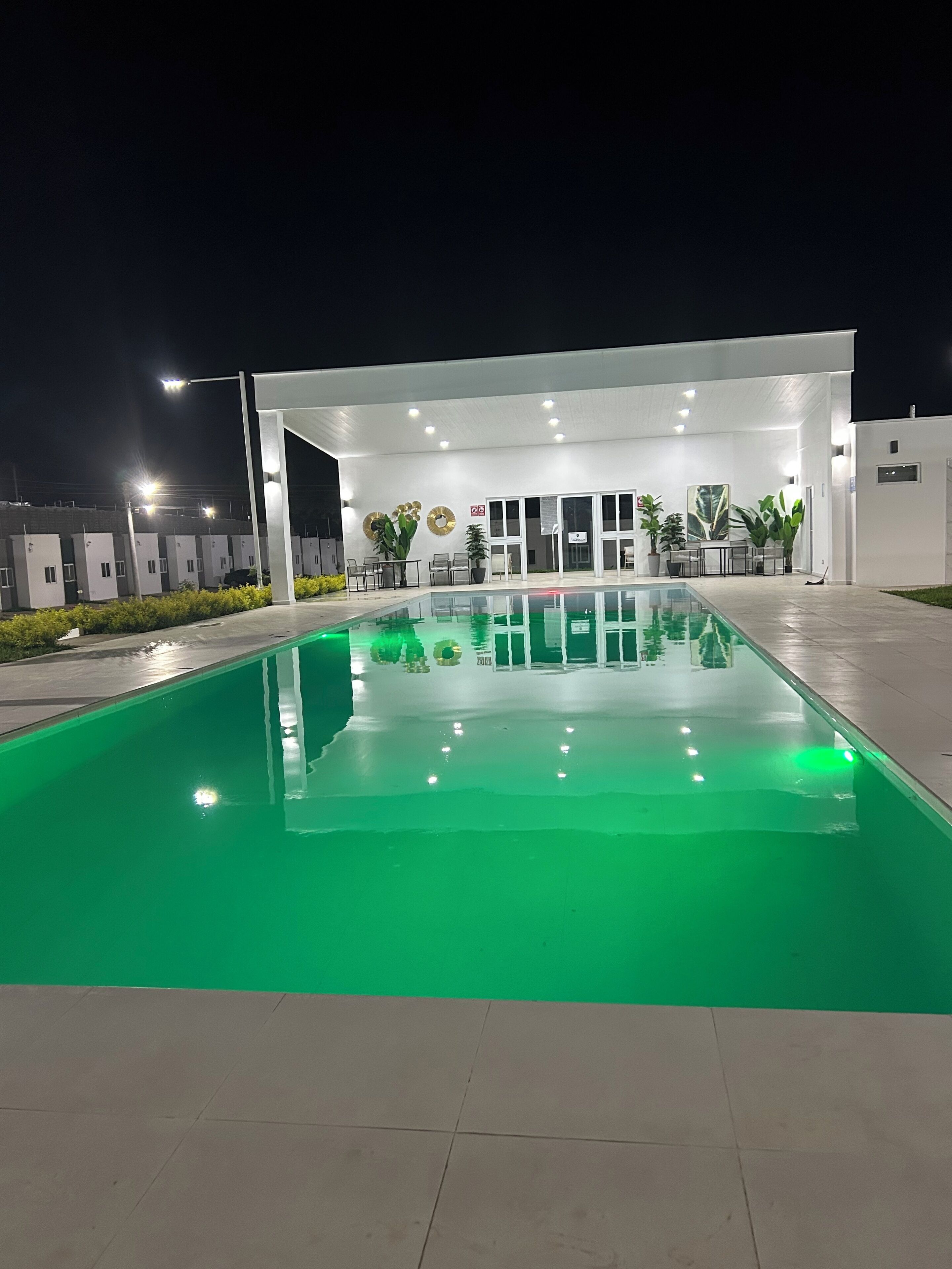 A swimming pool with a white building in the background.