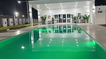 A swimming pool with a white building in the background.