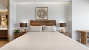 A neatly arranged bedroom with a large bed, two bedside tables, a small round table, and a wall-mounted decorative piece. - Two 501Full: The Ultimate Beachfront Getaway (Puerto Peñasco)