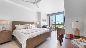 Ein modernes Schlafzimmer mit einem großen Bett, einem Schreibtisch und Blick ins Freie.