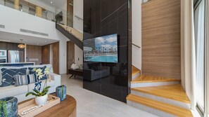 Ein modernes Interieur mit einer Treppe, Blick auf einen Pool und einem Essbereich.