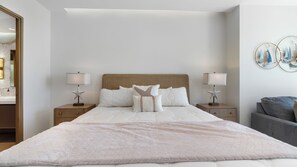 A hotel room with a large bed, two bedside tables with lamps, a chair, and a wall with decorative items. - One 101 : 👑 Azure Royale — upscale and memorable (Puerto Peñasco)