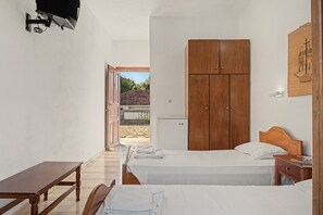 Ein Zimmer mit zwei Betten, einem Holzschrank, einem Schreibtisch und einem kleinen Tisch.