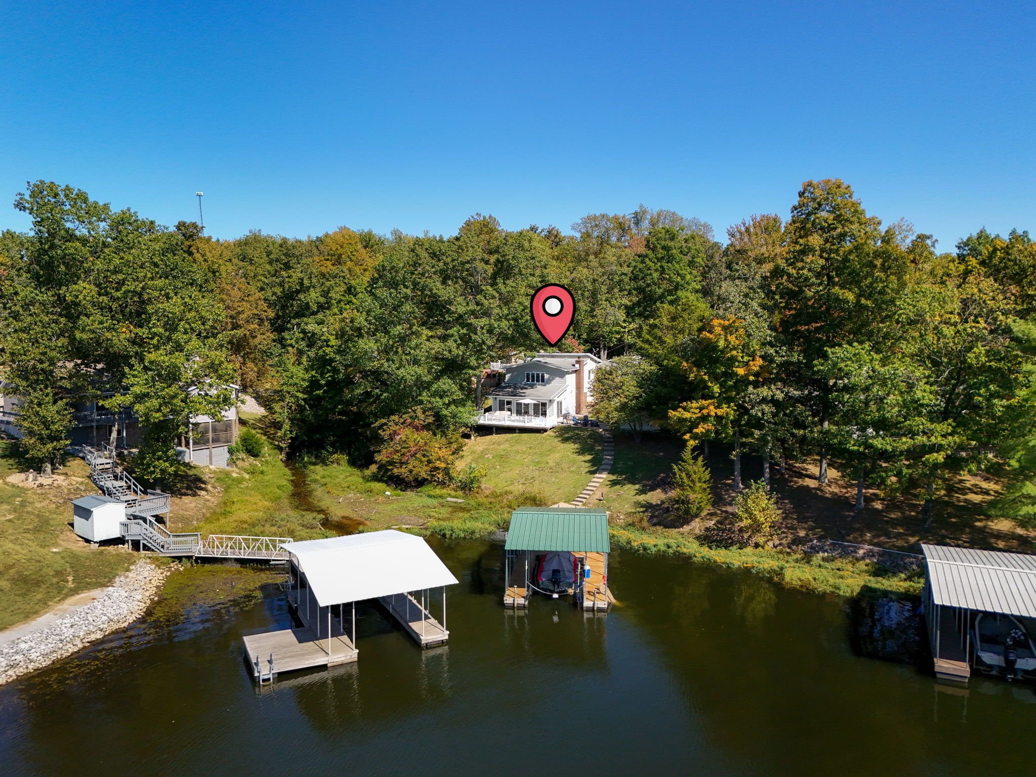 A lakeside property with a house, dock, and a small cabin.