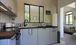A modern kitchen with a large island, a built-in oven, and a backsplash with geometric patterns. - Villa Clair de Lune - ANDERNOS LES BAINS (ANDERNOS LES BAINS)