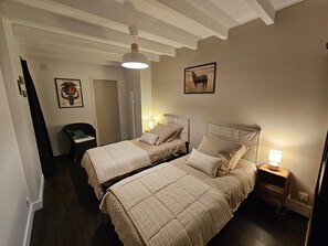 A hotel room with two beds, a chair, a desk, and a door. - Villa Clair de Lune - ANDERNOS LES BAINS (ANDERNOS LES BAINS)