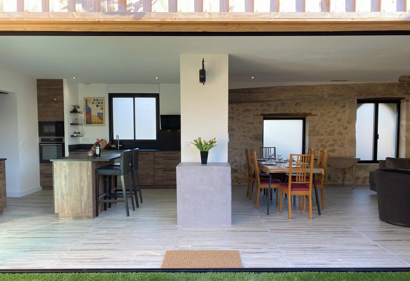 A modern interior with a kitchen, dining area, and a balcony with a view.