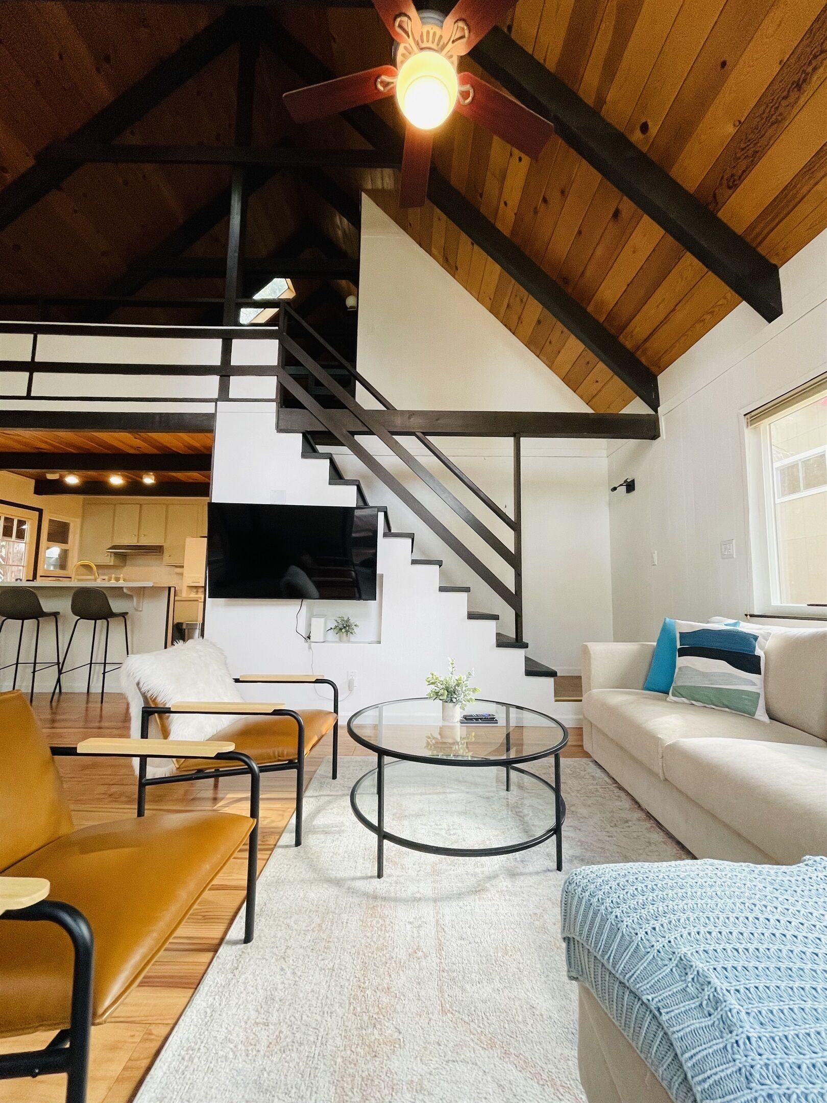 Ein modernes Interieur mit Treppe, Küchenbereich und Sitzgelegenheiten.