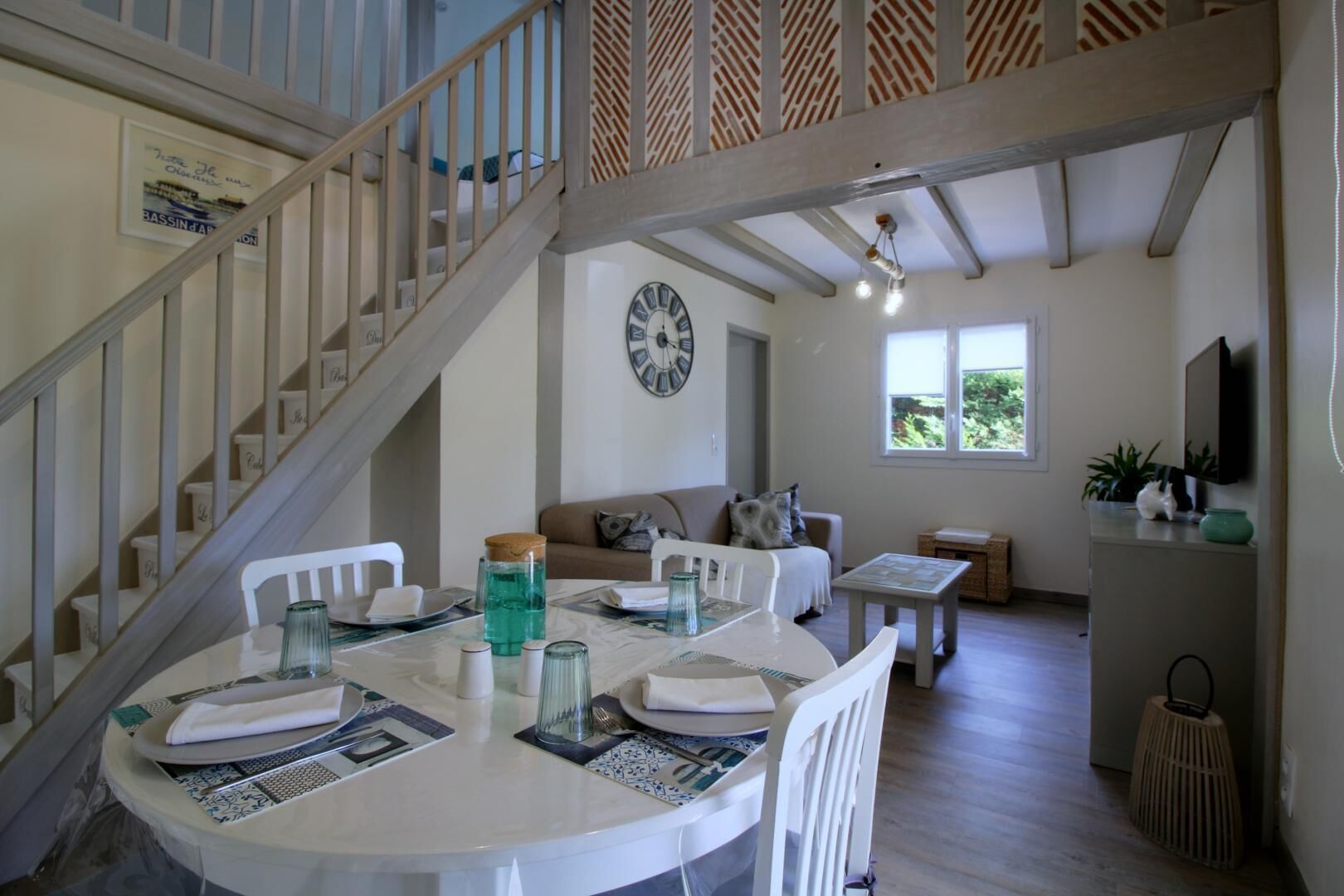 A dining area with a round table, chairs, and a clock on the wall.