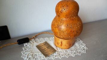 A wooden lamp with a label on a lace doily.