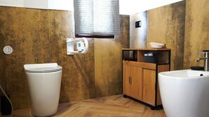 Un baño con inodoro, lavamanos y un mueble de madera.