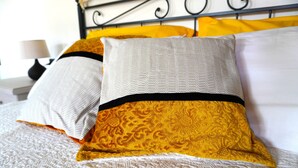 Una cama con almohadas estampadas y un cabecero.