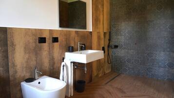 Un bagno moderno con un lavandino bianco, un bidet e una doccia.