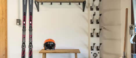 Un espace de rangement pour les skis, comprenant des paires de skis, un casque et une pelle.