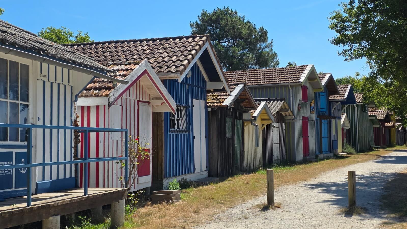 A row of colorful, single-story buildings with a rustic appearance, likely serving as accommodations.