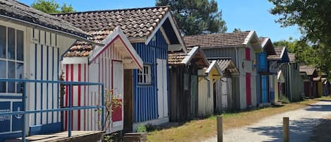 A row of colorful, single-story buildings with a rustic appearance, likely serving as accommodations.