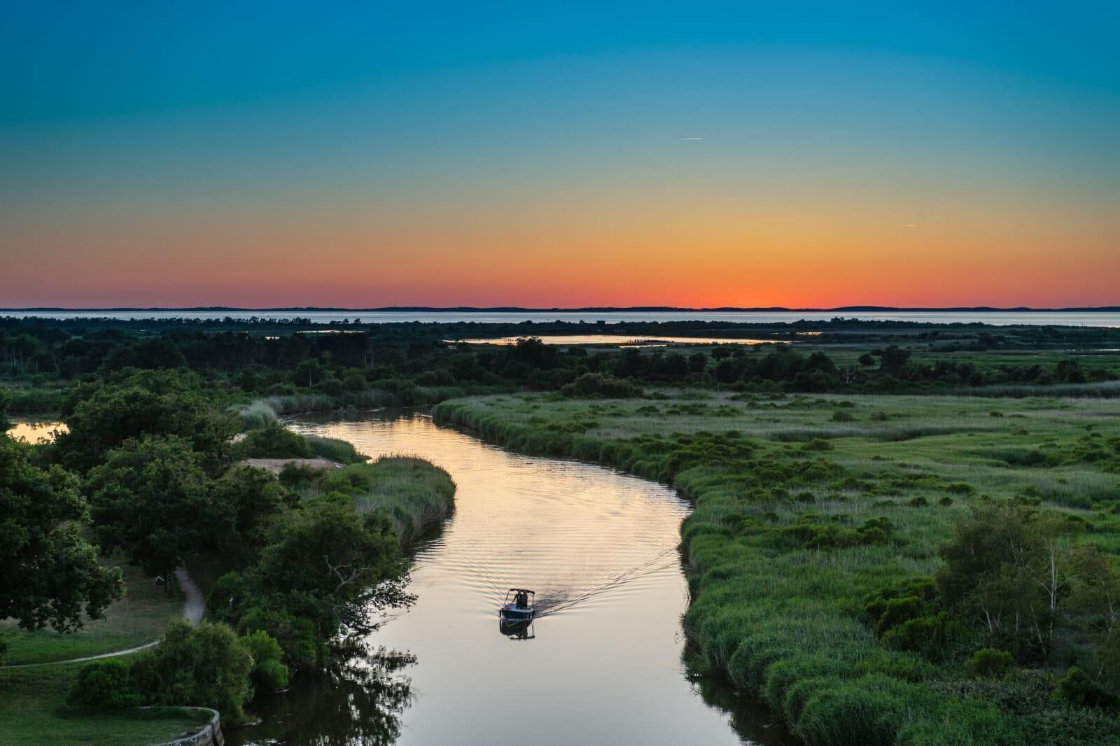A river meandering through a landscape with a boat in the water.