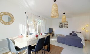 A modern living room with a dining area, a sofa, a TV, and a lamp. - L'Echappée du Bassin - ARES (ARES)