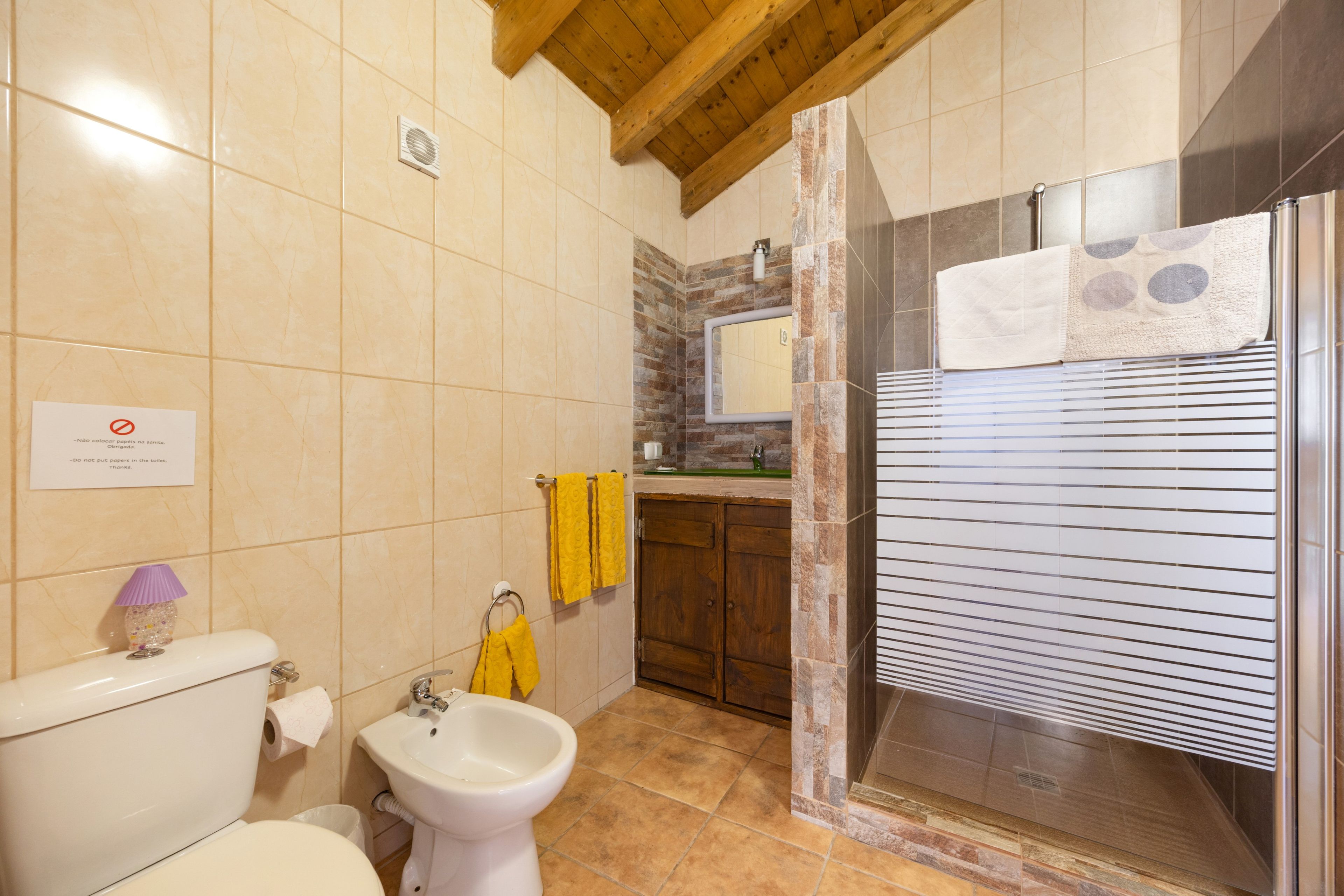 Une salle de bain comprenant des toilettes, un lavabo et un espace douche.