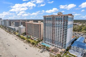 A high-rise hotel with multiple floors, a pool, and a beach view. - Paradise 510 - Oceanfront 3BR Condo w/ Pool (Myrtle Beach)