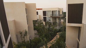 Een modern gebouw met meerdere balkons en een groene binnentuin.