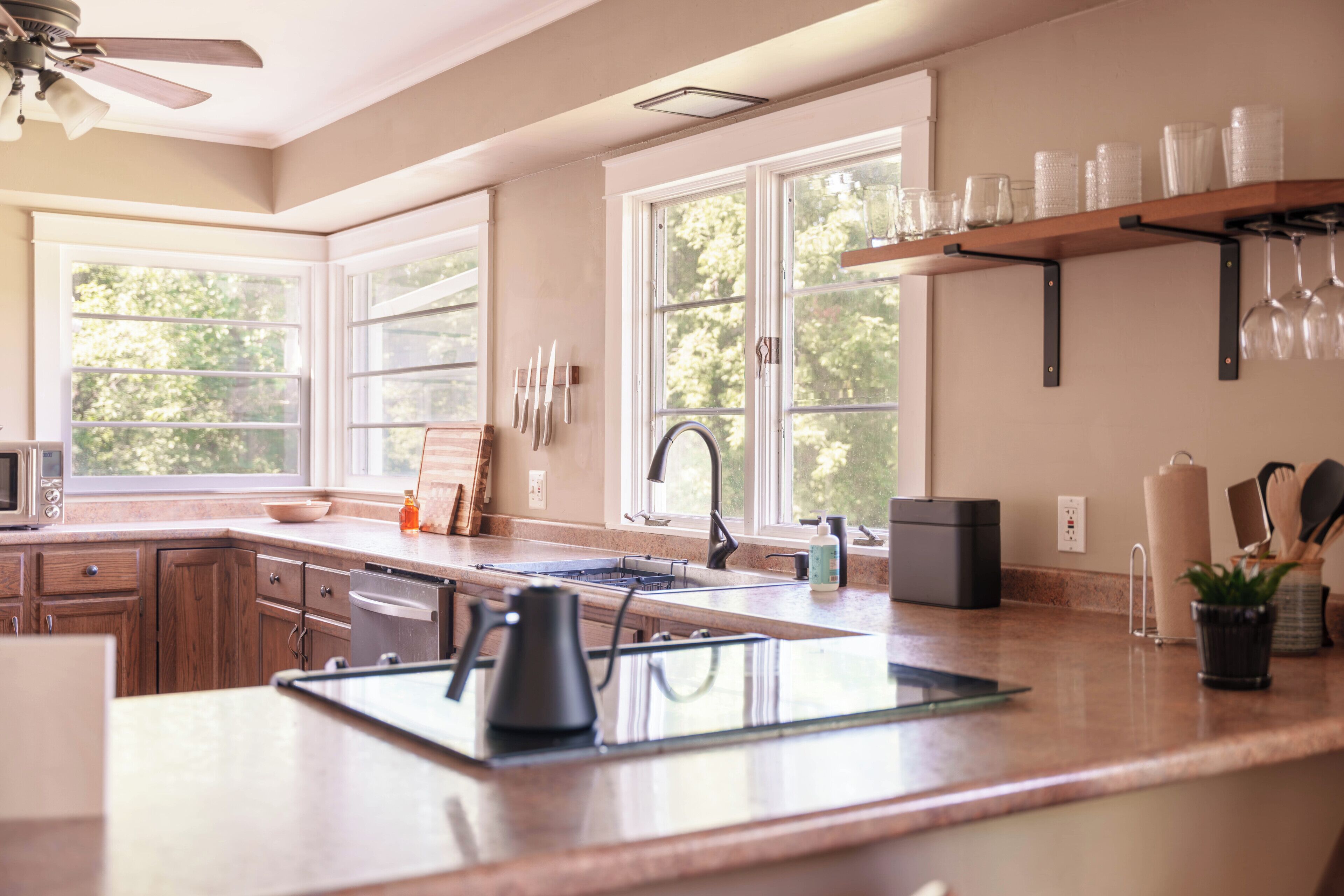 A modern kitchen with a large island, a microwave, and a sink.