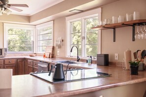 A modern kitchen with a large island, a microwave, and a sink. - The Rutland Ranch: 3 BR/1BA Renovated Home Close to Everything (Rutland)