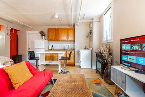 Ein kompakter Wohnbereich mit Küchenzeile, Essbereich und einer Sitzecke mit Fernseher.