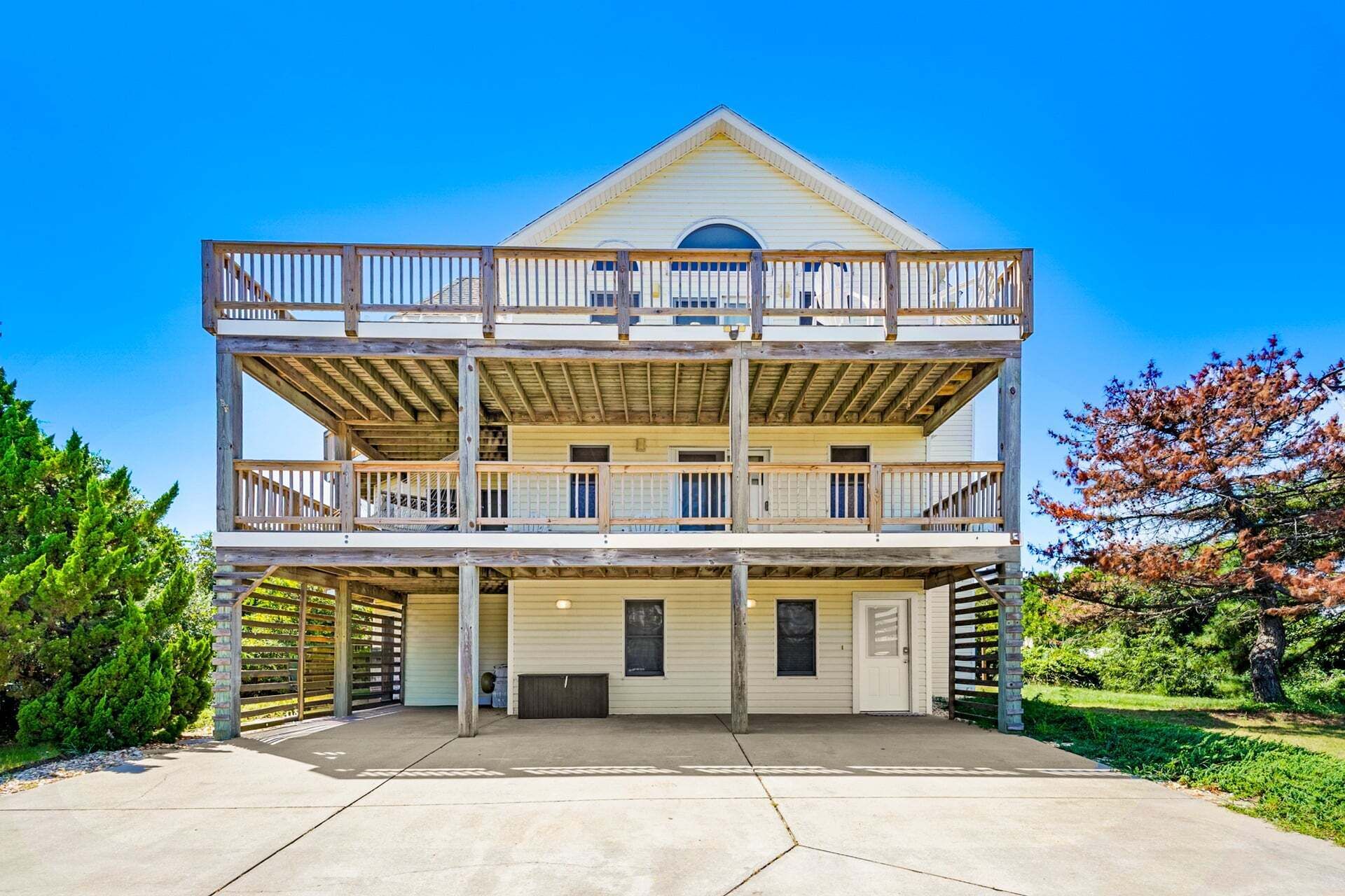 A two-story building with a balcony on the upper level, a garage entrance, and a clear sky.