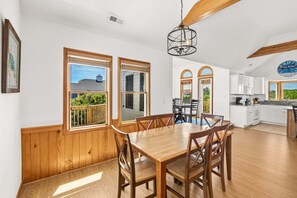 A spacious kitchen with white cabinets, a countertop, and a hanging light fixture. - Family Affair Corolla retreat with private pool, hot tub, and easy beach access. (Corolla)