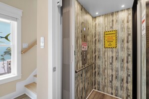 Ein Fahrinnenraum mit Holzvertäfelung, einem Warnschild und einer Tür, die die dritte Etage angibt.