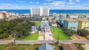 Un quartier résidentiel situé sur la côte, caractérisé par un imposant bâtiment à deux étages, un parking et des maisons aux façades colorées.