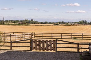 Paisaje rural con un portón de madera que da a un campo.