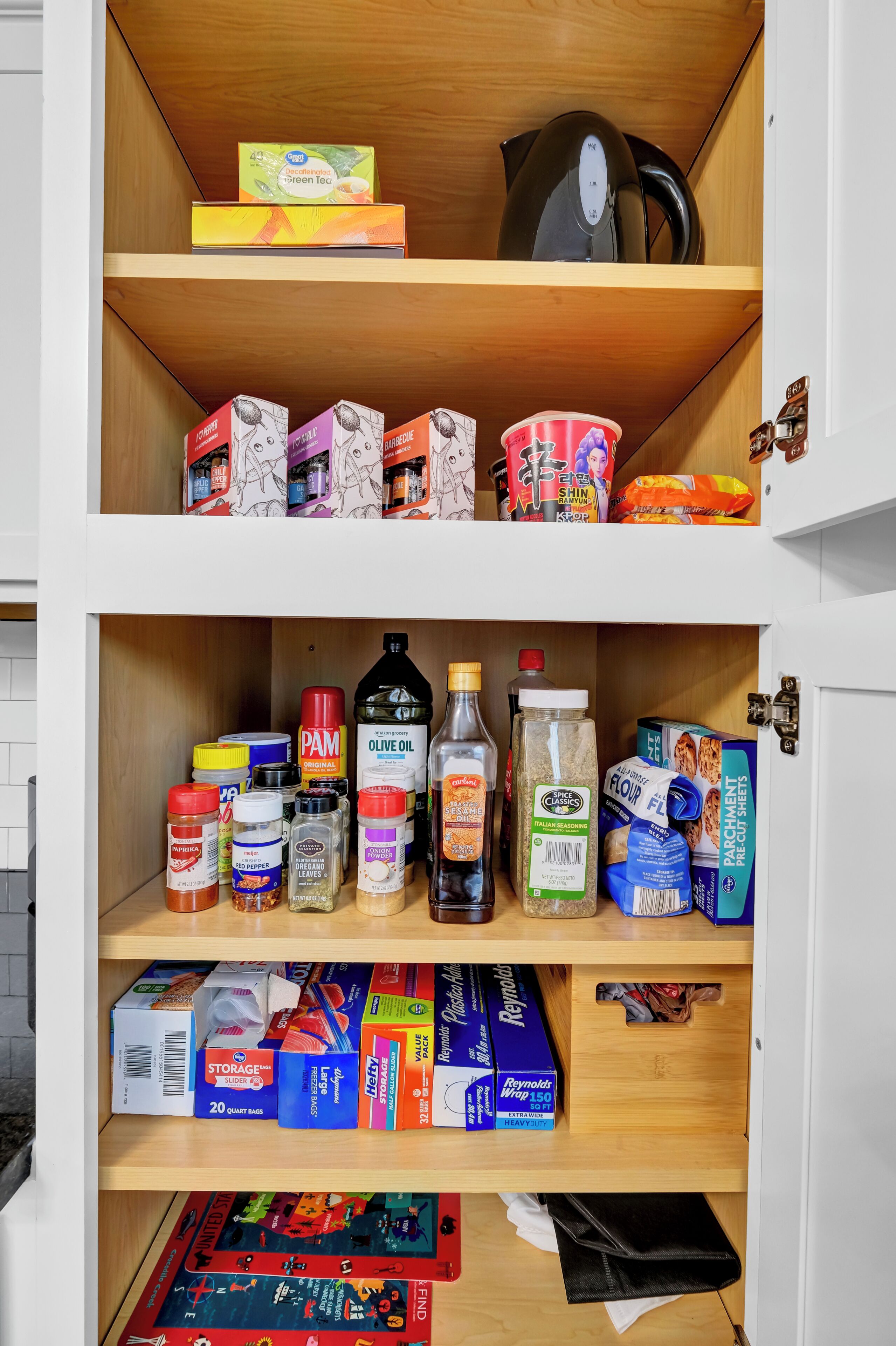 A kitchen pantry stocked with various food items and kitchen supplies.