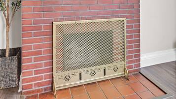 A fireplace with a brick wall, a mounted TV above it, and a sign that reads 'INDIANA' on the mantel.