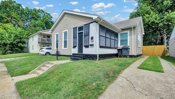 A two-story house with a front porch, a driveway, and a lawn.