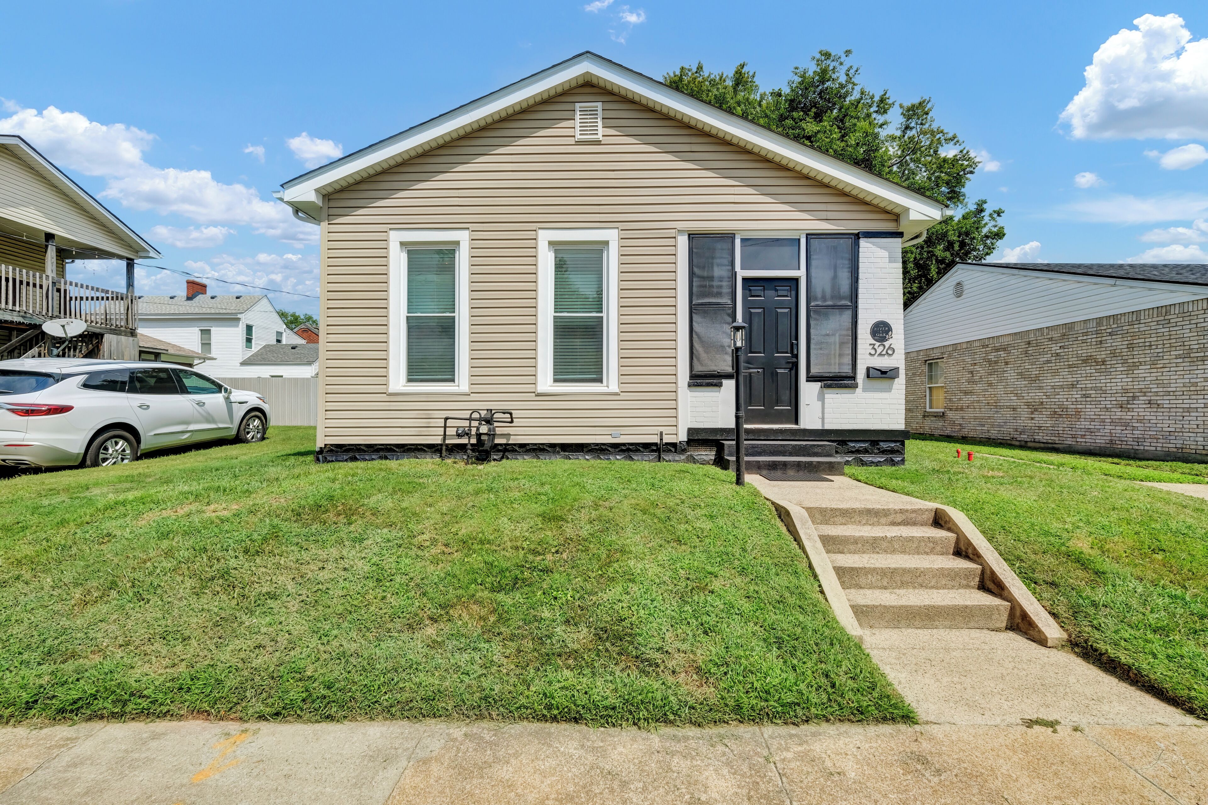 A single-story house with a front porch, a garage, and a well-maintained lawn.
