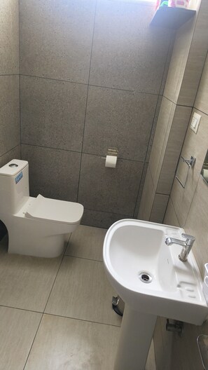 Un bagno con il water, un lavandino e un porta asciugamani.