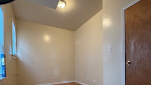 A room with wooden flooring, a door, and a window with blinds. - Welcoming 2-bedroom building with AC in vibrant Chicago (Chicago)
