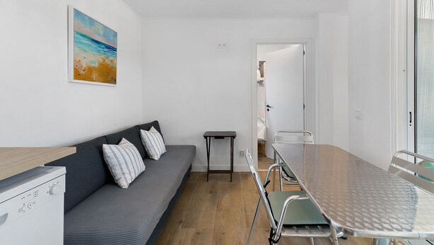 Une pièce de taille modeste, comprenant un canapé, une petite table et un lit.