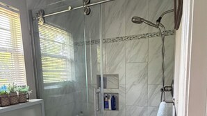 A bathroom with a glass-enclosed shower, a toilet, and a sink. - Charming 1-bedroom/bathroom in a home in Warner Robins (Warner Robins)