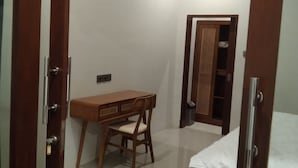A bedroom with a wooden bed, a desk, and a chair.