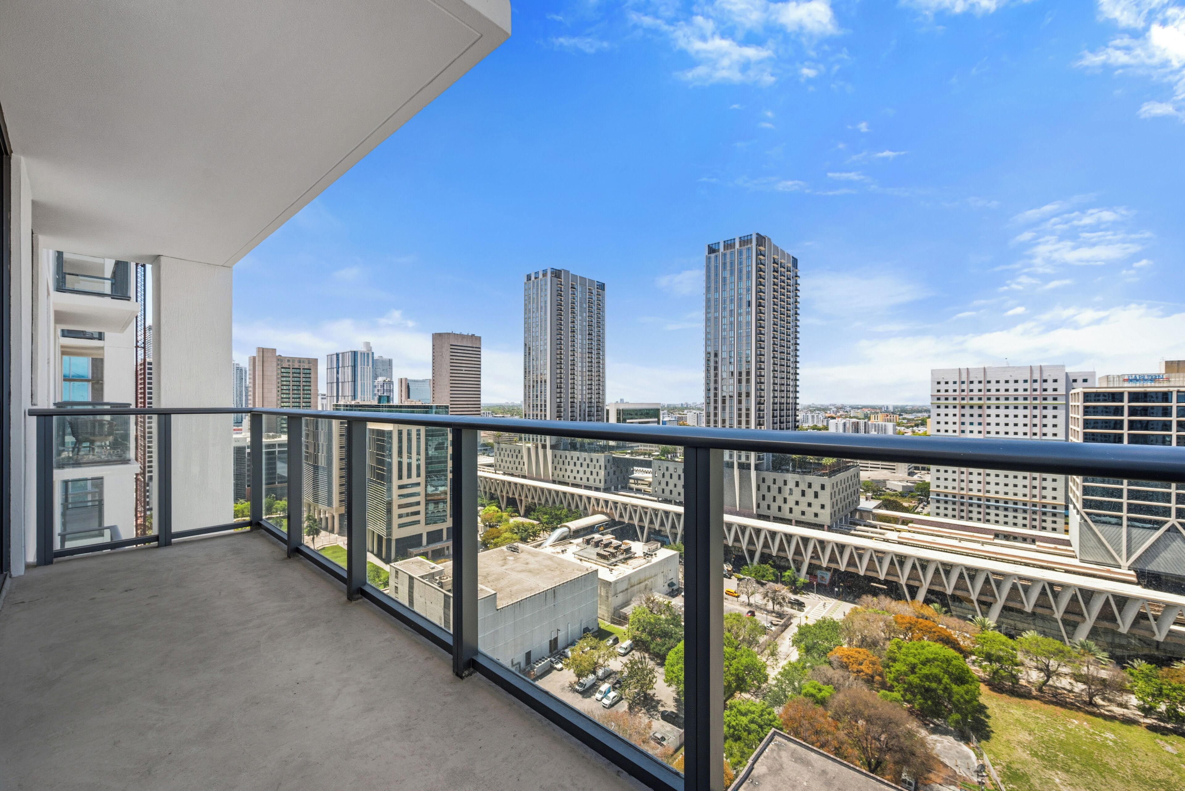A balcony with a city view overlooking high-rise buildings.