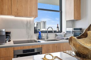 Una cocina moderna con lavavajillas integrado, cafetera y ventana con vista a la ciudad.