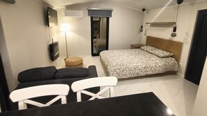 Ein gemütliches Schlafzimmer mit Bett, Nachttischen, einer Lampe, einem Spiegel und einer Deckenleuchte.