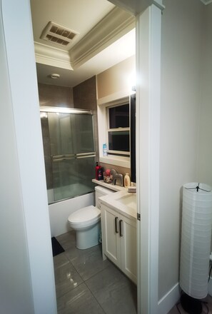 Een badkamer met toilet, wastafel en douche.